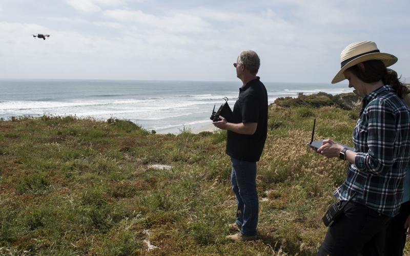 On the beaches at Camp Pendleton, Cory Stephanson, president and CEO, Broadband Discovery Systems Inc., launches a sensor-laden drone that collects data about buried mine materials while Dr. Rosemarie Oelrich, scientist, Naval Surface Warfare Center Carderock, monitors the information on a handheld Android device.