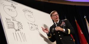 Maj. Gen. Stephen Fogarty, USA, commanding general of U.S. Army Cyber Center of Excellence at Fort Gordon, Georgia, takes to the white board to illustrate dysfunctional stovepipes that keep military disciplines from sharing information and missions. Photo by Mike Carpenter