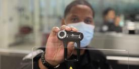 A U.S. Customs and Border Protection Officer at Dulles International Airport in Virginia holds up a camera used for facial biometric process. The agency is deploying biometric identity solutions to six more international airports in the southern United States. Credit: CBP