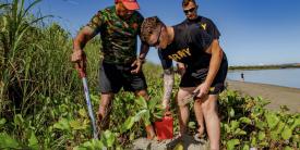 Two U.S. Army specialists join a Fijian Army sergeant in planting Dilo trees as part of a coastal and reef revitalization project in the Republic of Fiji. The U.S. Army works with local officials domestically and overseas in projects to support environmental concerns to avoid or repair damage.