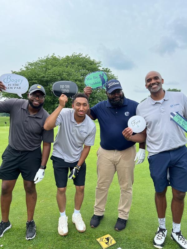 Team OMNI has some fun at the photo booth at the annual golf tournament in July.