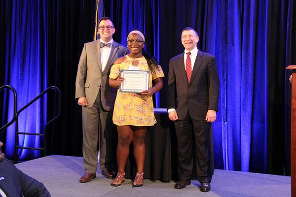 Elkton High School senior Olayide Ashiru, chapter scholarship recipient, accepts her award at the chapter's May scholarship dinner from former Chapter President Mike Bowen (l) and guest speaker Larry Muzzelo, deputy to the commanding general, U.S. Army Communications-Electronics Command.