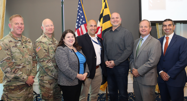 October speakers and chapter representatives are pictured (l to r): Lt. Col. John P. Cross, USA; Lt. Col. Troy Merkel, USA; Chapter President Lauren Beward; Noel Lynkew; Garry Moore; Fran Orzech, and Association of Old Crows Chapter President Pete Scucces.