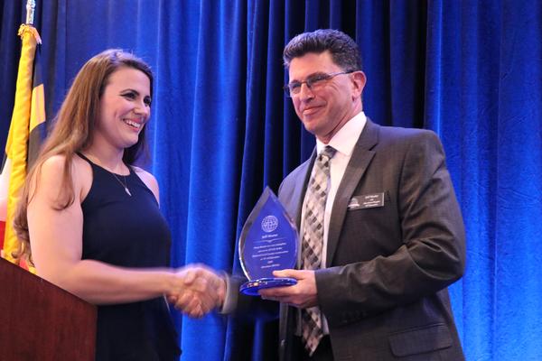 Vice President of Awards Mallory Arnold (l) presents former Vice President of Education Jeff Murter with an award of recognition for his seven years of volunteer service at the May event.