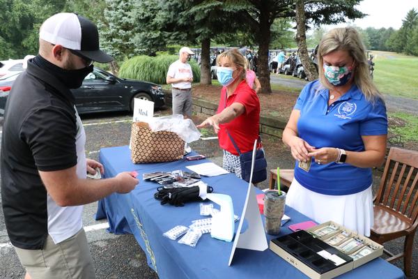 At the July event, staff at the AFCEA International Aberdeen Chapter Annual Golf Tournament support attendees as they sign in at the entrance of the Wetlands Golf Course.