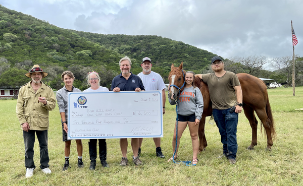 In July, Jeff Kendall, chapter vice president, Veteran Support and Military Family Outreach, presents a $6,500 check to Kink and Marcie Friedman of Echo Hill Ranch during their Gold Star Kids Camp. The camp focuses on "kids being kids" with horseback riding, archery, swimming and crafts on the gorgeous property just north of Bandera, Texas.