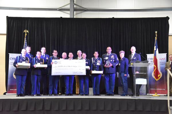 Chapter President Rick Lipsey (far r) and Vice President of Scholarships and Educational Grants Karen Rolirad (2nd to r) present the Best All Female Team, Alamo Heights Army JROTC, with $6,000 in scholarships during the 9th Annual San Antonio Mayor's Cyber Cup in March.