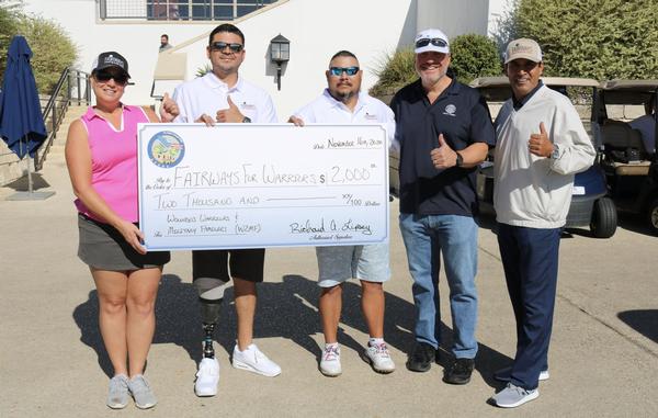The chapter's vice president of veteran support and military family outreach presents a $2,000 check to Fairways for Warriors during the November event. 