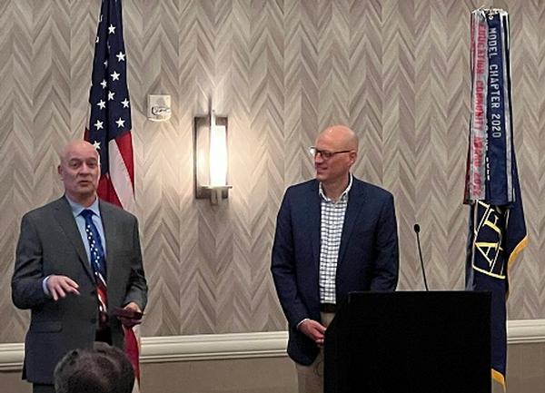 Brian Cook, 16th Air Force technical director (l), and Chris Kinne, chapter president, present at the chapter's February luncheon.