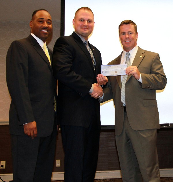 Jacob Stauffer (c), commander of Alamo region Civil Air Patrol unit, receives a $6,610 grant to support a new CyberPatriot training initiative from Keith Jordan, chapter vice president of scholarships and grants (l) and Chapter President Bill Morrow in July.