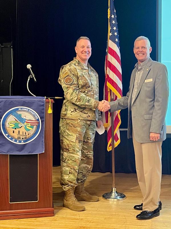 Chapter President Rick Lipsey presents Brig. Gen. Robert Lyman, USAF, assistant deputy chief of staff for Cyber Effects Operations, Air Force A-2/6, with a coin during the chapter's first in-person luncheon held in August. Gen. Lyman discussed the accelerating change in information warfare to members and attendees.