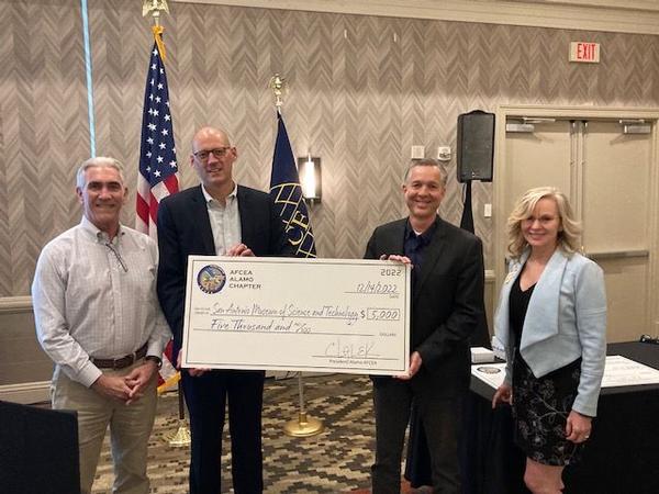 Chapter President Chris Kinne presents a coin to guest speaker Col. Lauren Courchaine, USAF, during the December monthly luncheon. Col. Courchaine is the commander of the 37th Training Wing, Joint Base San Antonio-Lackland, Texas.�