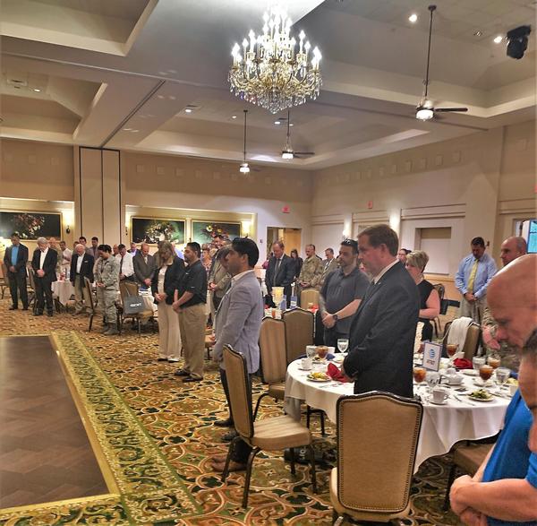 Chapter members and attendees stand for the Pledge of Allegiance and invocation during the chapter's September Lunch. Learn. Network. event. 