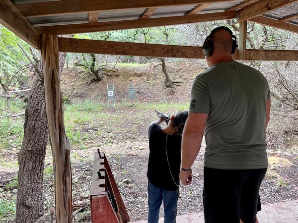 Chris May, rifle range instructor and vice president of the Marine Reconnaissance Foundation, helps a minor during rifle range practice. This is one of the many activities held during the Echo Hill Ranch Camp for Gold Star Kids sessions.