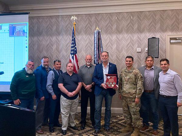 The chapter presents Semper Valens Solutions with a five-year membership plaque for their continuous support of the chapter during the October monthly luncheon.