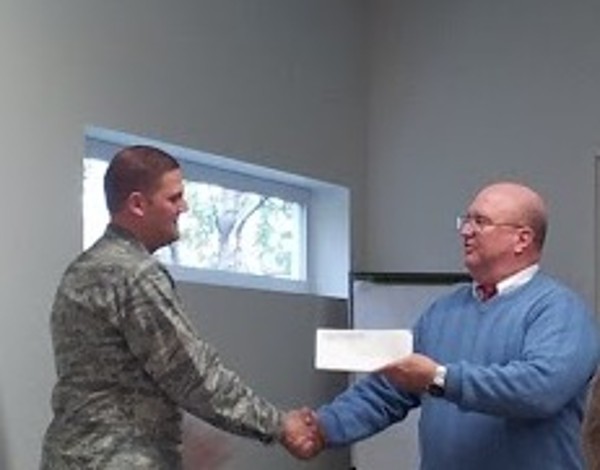 Ed Ryglewicz (r), regional vice president, presents a $1,000 STEM grant to Lt. Col. Brian Hippel, USAF, newly elected chapter president, in October.