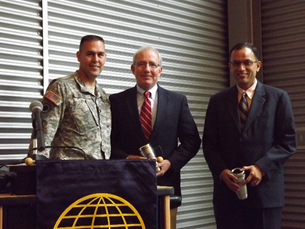 Lt. Col. Dave Elder, USA (l), chapter president, presents AFCEA mugs to Jeff Roe (c), vice president of federal marketing for General Communications Incorporated, and Anand Vadapalli, president and chief executive officer of Alaska Communications, who both spoke at the September luncheon.