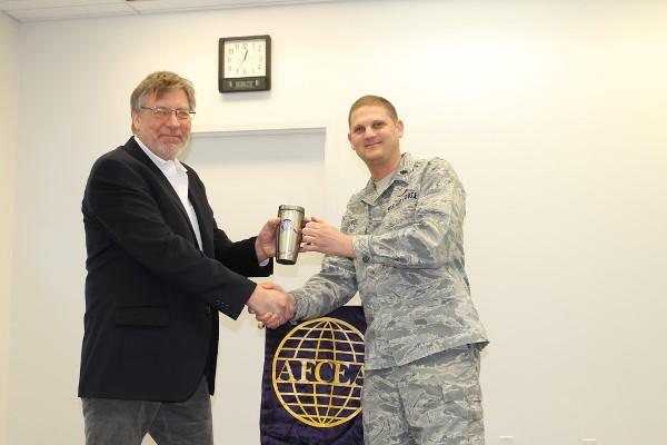 Michael Grueber, from National Oceanic and Atmospheric Administration Federal, receives an AFCEA mug from Brian Hippel, chapter president, for his presentation at the January luncheon.