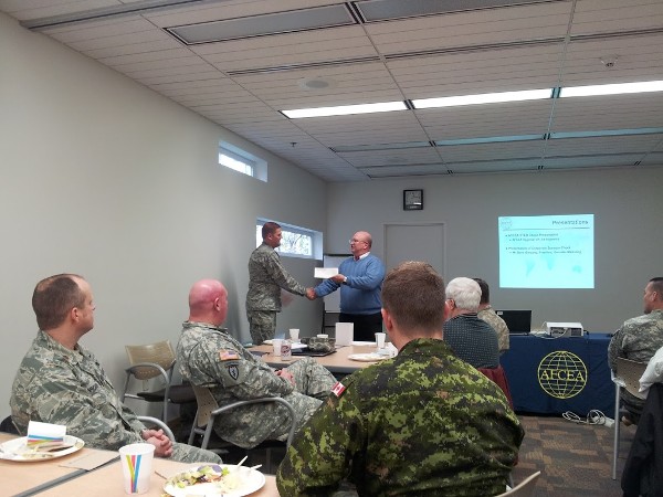 In October, Ed Ryglewicz (r), regional vice president, presents a $1,000 STEM grant to Lt. Col. Brian Hippel, USAF, newly elected chapter president, while chapter members look on.