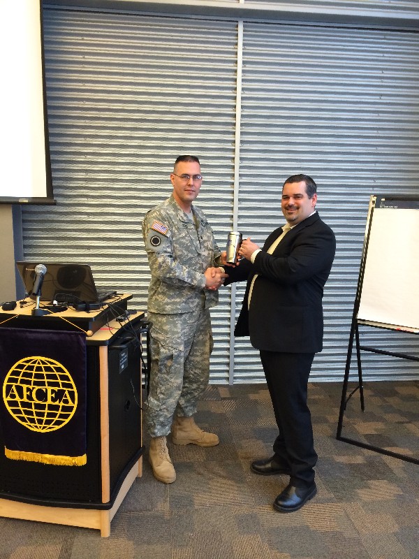 Col. Elder (l) presents Charles Bock, government account manager for Verizon Wireless, with a chapter mug following his presentation at the January luncheon.
