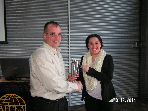 Master Sgt. Paul Kodiak, USAF, chapter first vice president, presents a token of appreciation to Lauren Seawright, an intelligence analyst with the FBI Anchorage Field Office, for her presentation on cyberthreats and their impact on Alaska.