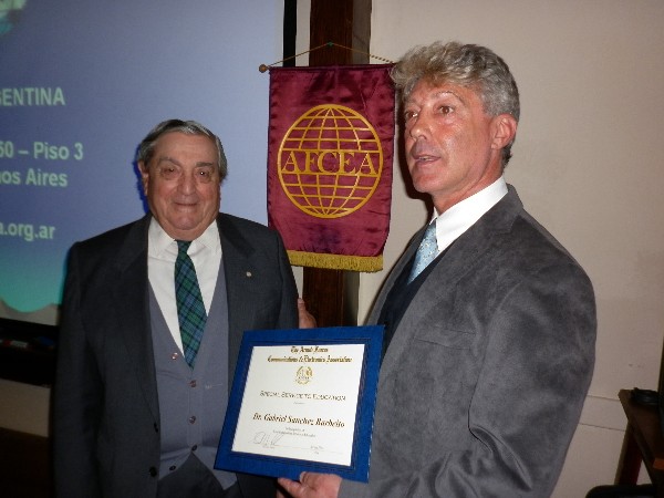 In September, Rear Adm. Emilio Nigoul, ARA (Ret.) (l), chapter president, presents a framed certificate to Gabriel Sanchez Barbeito, chapter board member, in recognition of his services to education.