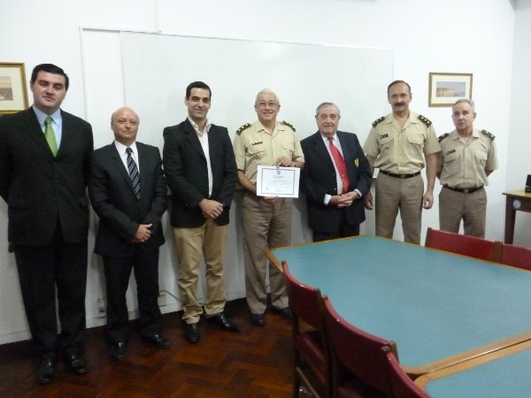 Rear Adm. Emilio Nigoul, ARA (Ret.) chapter president (third from r) presents a check and certificate to Col. Enrique Nogueira, director of the military (c) in December.