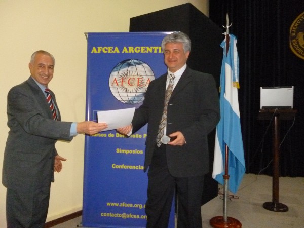 Maximo Ricci (r) receives a certificate of recognition from Luis Favotto, Argentina chapter board member, at the October Nanotechnology Symposium.