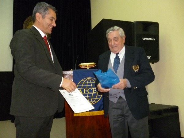 Walter Aguero (l) receives a certificate of recognition from Rear Adm. Nigoul in May.