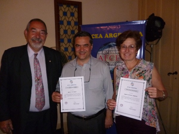 Juan Carlos Fondevila Sancet, AFCEA regional vice president for South America (l), presents certificates of appreciation to Luis Valle and Claudia Cardama, event coordinators, in December.