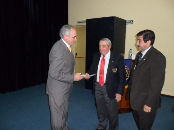 At a conference in May, Adm. Nigoul (c) and Col. Tello (r) present a certificate to Cmdr. Eduardo Zanardi, FAA (Ret.).

