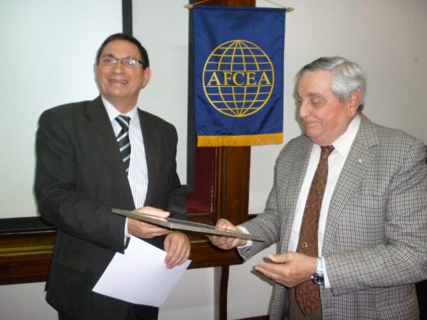 ARGENTINA—In May, Rear Adm. Nigoul presents a Distinguished Membership frame to Eng. Pesado recognizing their important collaboration and support given to the Argentina chapter.
