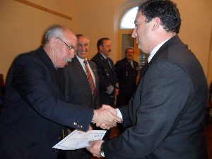 In September, Col. Oscar Gonzalez, FAA (Ret.) (l), chapter board member, presents a certificate to an attendee of the symposium on intelligence, surveillance and reconnaissance.