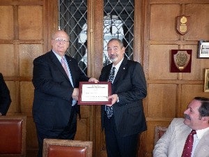 Kent Schneider, president and chief executive officer of AFCEA International, presents an award to Juan C. Fondevila Sancet, regional vice president for South America, during the April meeting.