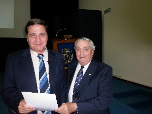 Rear Adm. Emilio Nigoul, ARA (Ret.) (r), chapter president, presents a certificate of recognition to guest speaker Nicolas Mendez Guerin at the March conference.