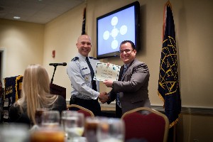 Lt. Col. Curtis Juell, USAF (l), chapter president, presents Jonathan Galaviz, the managing director of Galaviz & Company, with a one-year AFCEA membership following his speech to the chapter in February. Photo courtesy of Jim Noetzel.