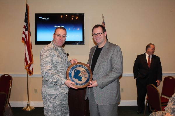 Col. Frank Simcox, USAF, chapter president, presents Rory Welch, chief executive officer of WaLa!, with a chapter plaque in appreciation for his speech at the February luncheon.