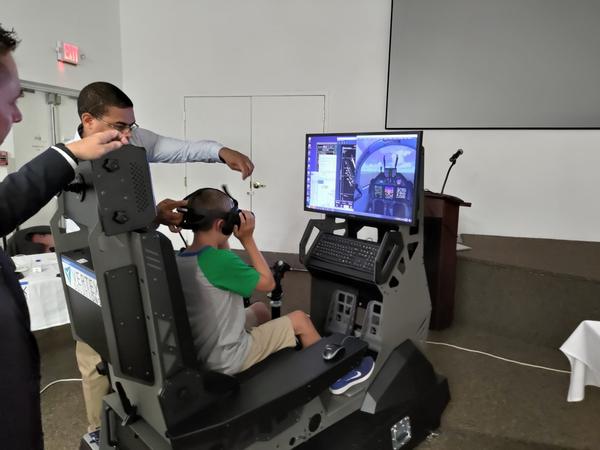 Vertex Solutions walks an attendee through a virtual ride on an aircraft simulator at the July event.