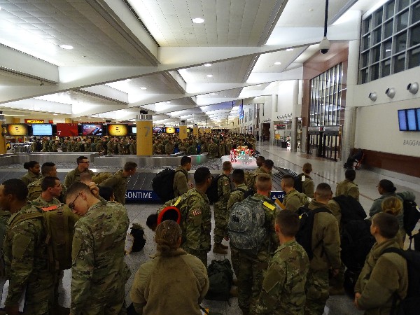 Soldiers in transit gather in the terminal before departure and receive goody bags from the chapter in December.