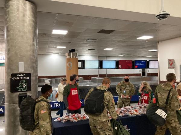 Fort Gordon Communications CoE students pick up their goodie bag treats on the way to their departure gates. Mary Lou Austin (center r), director of Region IV United Service Organization, chats with Sgt. Chuck Schara, Fort Gordon.