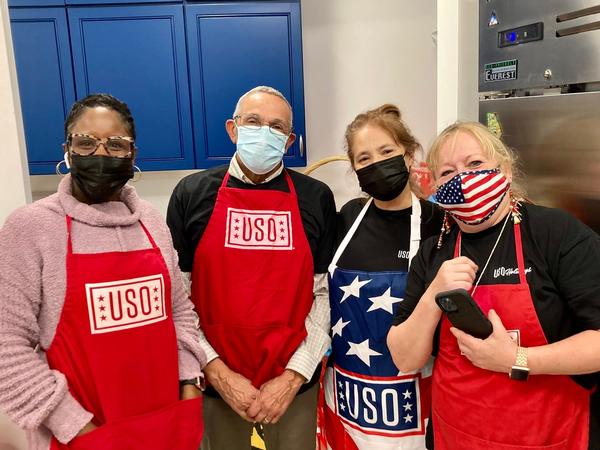 Veronica Briggins, Johnnie Young, Laura Kefalas and Donna Serog take a break from handing out hot dogs and snacks to the troops waiting on the second leg of their flight home in December.