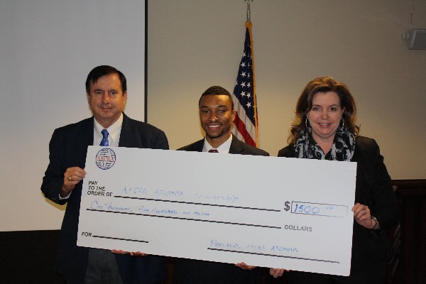 Austin Little (c) accepts his scholarship check from Landry and Goetz at the chapter's February luncheon. 