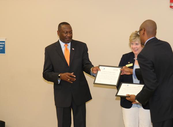 At the April event, Col. Sly Cotton, USA (Ret.), chapter president, receives a certificate of appreciation for AFCEA's support of this much anticipated project as Kelly Knitter looks on.   