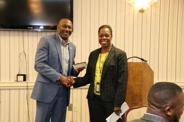 Col. Sly Cotton, USA (Ret.), chapter president, presents Queen-Harper with a speaker gift at the April event.  