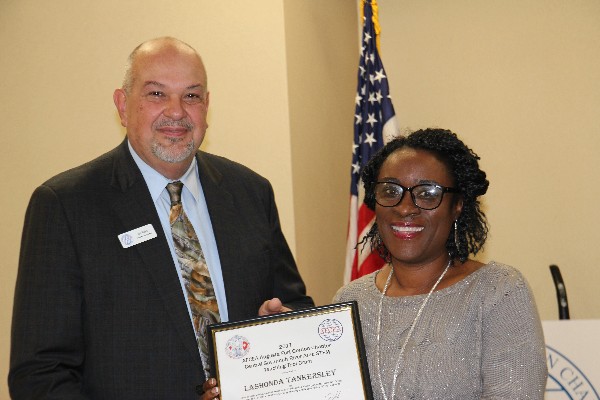 Hains Elementary teacher Tankersly receives a certificate and congratulations from Velez in January.