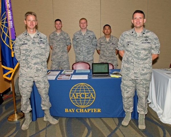 Along with young AFCEAN volunteers, Lt. Col. Patrick Godfrey, USAF (l), outgoing president, and incoming President Lt. Col. David Lowery (r), USAF, work at the chapter booth at the June technology expo. 