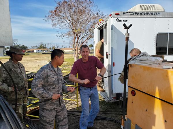 In February, Chief Master Sgt. Lafoundra Thompson, USAF, vice president of enlisted affairs, keeps watch as 1st Lt. Toney Doan, USAF, chapter secretary, and Eric Grath, cable and antenna systems technician, 325th Communications Squadron, pull cable in preparation for relocating a core network node damaged by Hurricane Michael. 