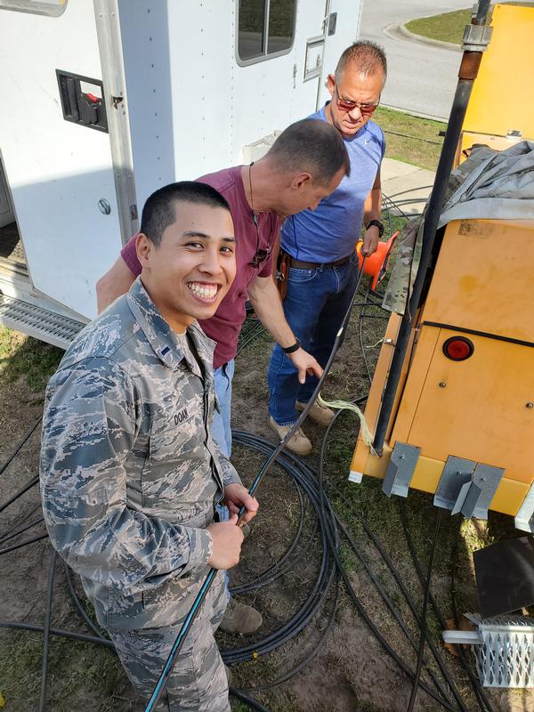 In February, Lt. Doan smiles for the camera as he assists with pulling new cable in preparation for moving a core network node damaged by Hurricane Michael. 