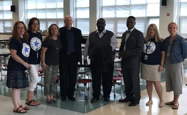 Chapter board members (c, from l) Bill Jones, Reginald Vaughn and Ivan Johnson present more than $6,000 in gift cards in August to Fort Belvoir Elementary Campus teachers. They pause for a photo with staff, including (l-r) Betsy Stickel, Nancy Rowland, Kara Fahy, Jamey Chianetta and Margo Dias-Pareja.