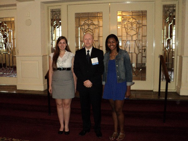 Bill Jones, chapter president, congratulates two scholarship recipients in June.